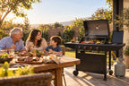 Familia disfrutando un asado en el patio con parrilla a gas Arrayán de Reptilia